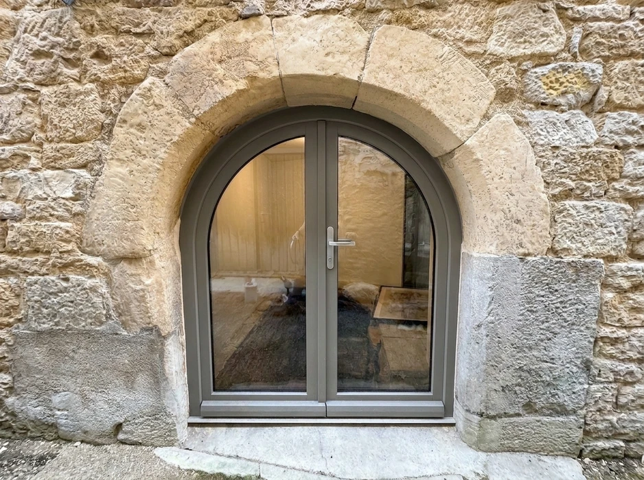 Atelier de menuiserie intérieur avec grande baie vitrée coulissante à châssis bois en cours d'assemblage, posée au sol