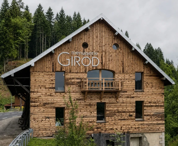 Artisan menuisier travaillant le bois dans un atelier, utilisant un rabot à main sur une planche